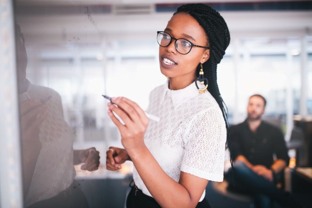 business woman at an MSP writes business continuity strategy on whiteboard