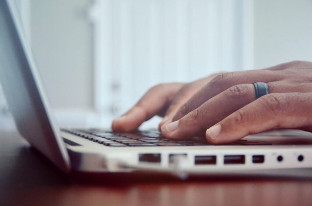 man typing on laptop