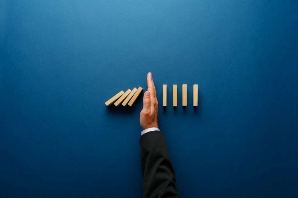 business man keeps jenga dominos from falling