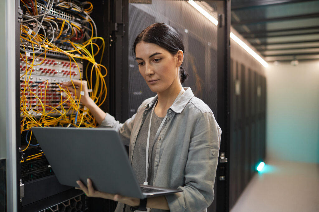 female network technician inspecting servers