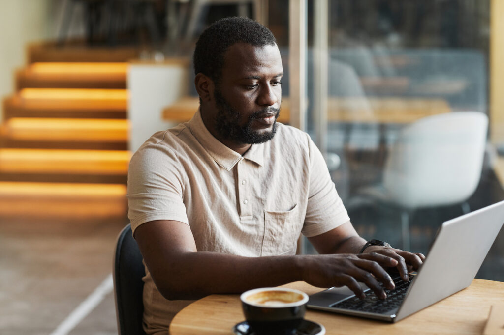 man working in hybrid workspace utilizing cybersecurity tactics to avoid cyber threats